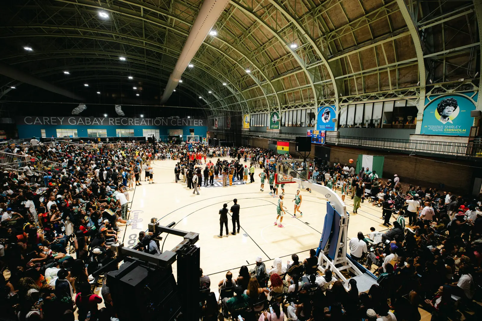 A packed crowd surrounding the court during a Battle of Jollof game