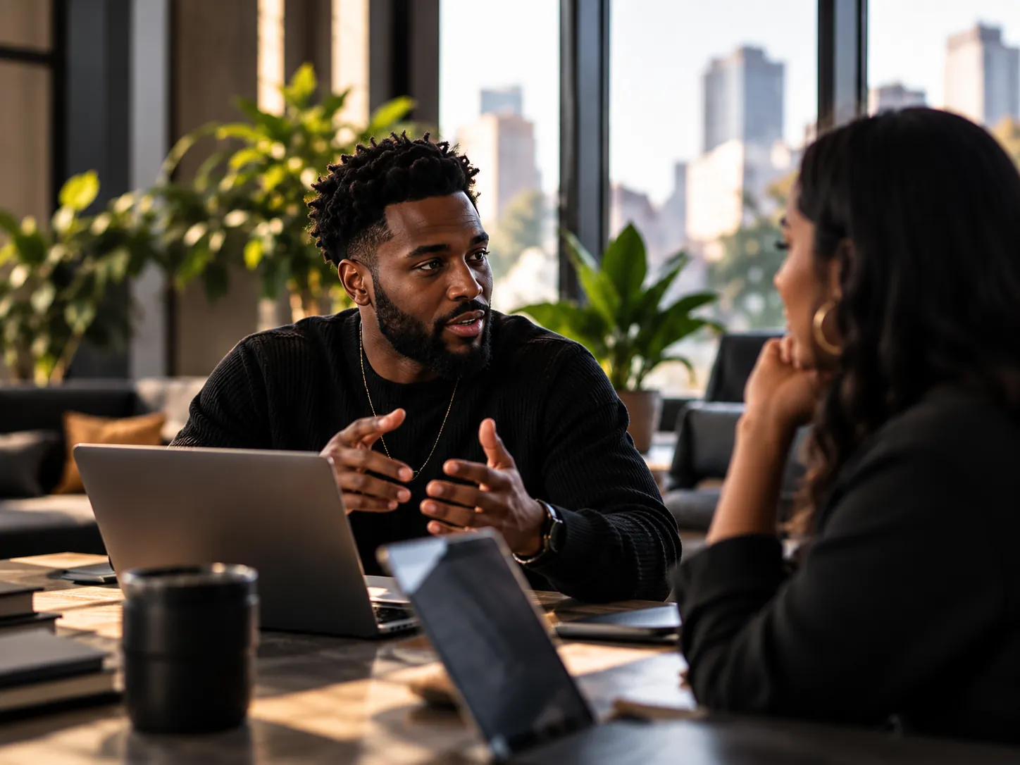 A partnership strategist talking through a plan with a creator across a table in a sunlit office